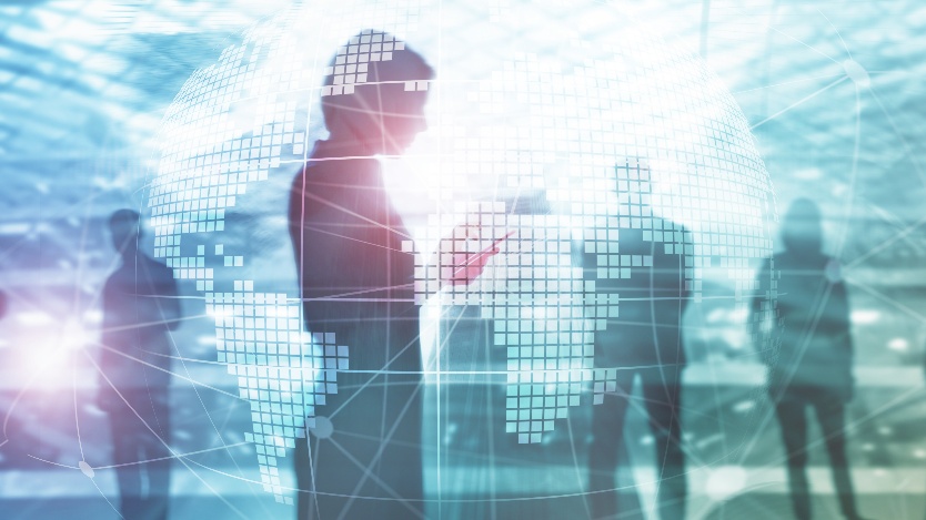 Human silhouettes standing within a luminous digital globe and network grid